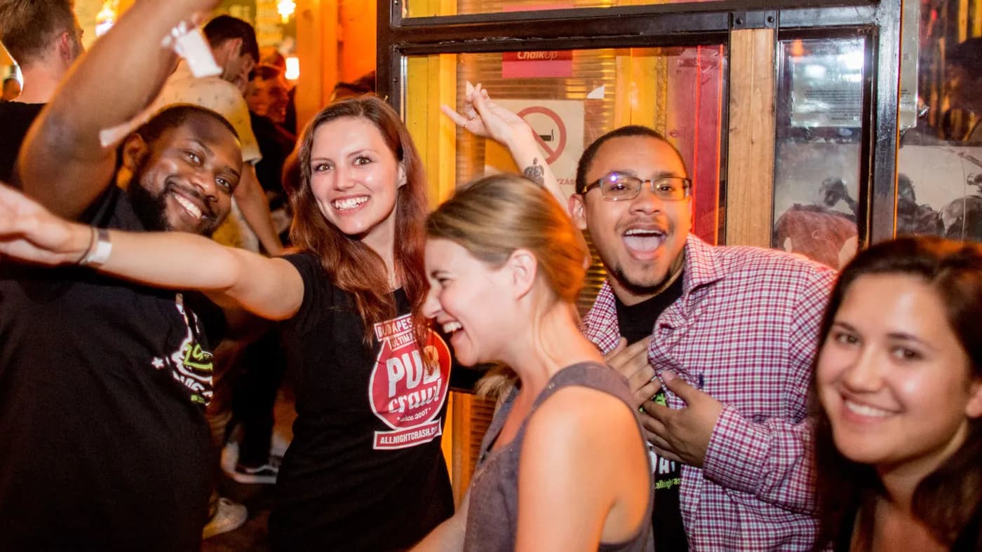 A small group of travellers laughing together at night on a real Pub Crawl Budapest night