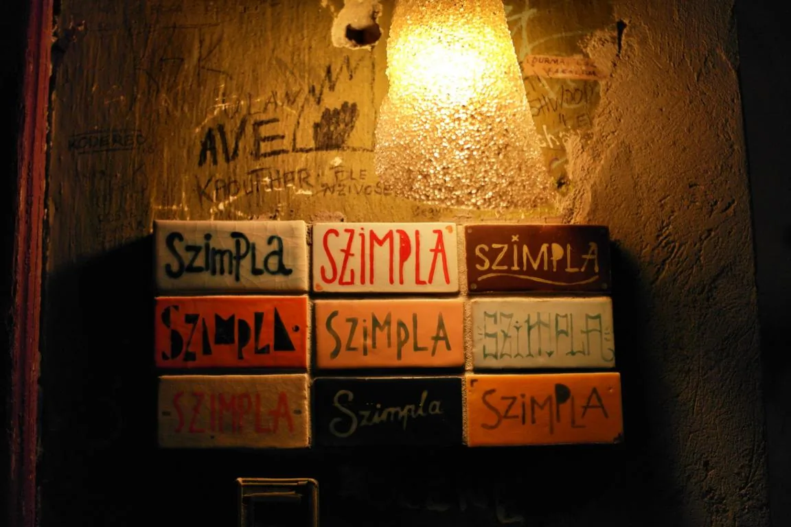 Warm lamplight over the eclectic, mismatched furniture of Szimpla Kert, Budapest